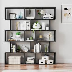 a living room filled with lots of furniture next to a wall mounted shelf full of books