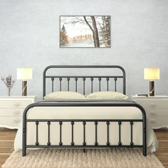 a black metal bed frame in a bedroom with white walls and wood flooring, along with two lamps on either side of the bed