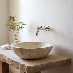 a bowl shaped sink sitting on top of a wooden table