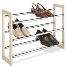 four pairs of shoes are hanging on a rack with two bars and one pair is closed