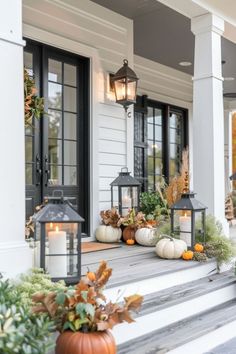 front porch decorated for fall with lanterns and pumpkins