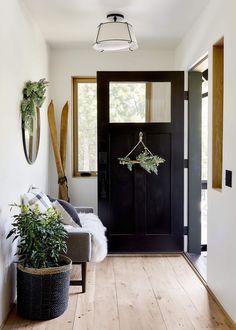 a black front door with white walls and wood floors