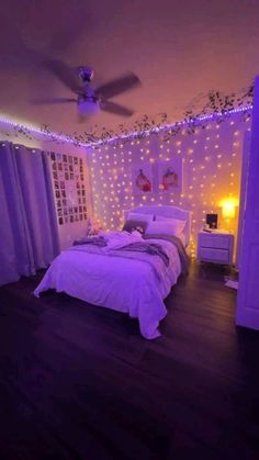 a bedroom decorated in purple and white with fairy lights