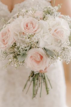 a bridal holding a bouquet of white and pink flowers