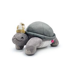 a stuffed turtle with a gold crown on its head is sitting in front of a white background