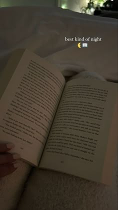 an open book sitting on top of a bed