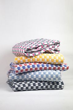 a stack of folded shirts sitting next to each other on top of a white surface