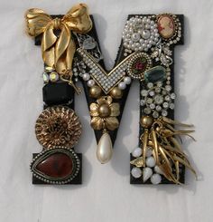 the letter m is made up of many different types of beads and other things on it