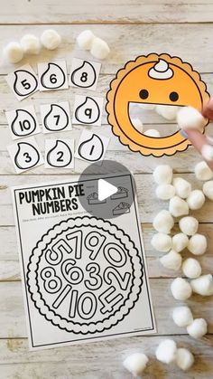 a person holding marshmallows next to a piece of paper that says pumpkin pie numbers