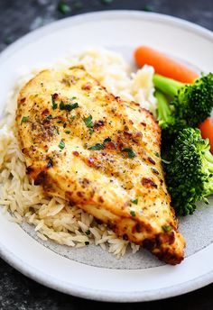 a white plate topped with chicken, rice and vegetables