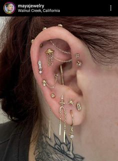 a woman with many piercings on her ear and behind the ear is a cross