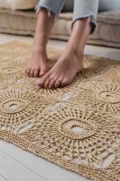 a woman is sitting on the floor with her feet propped up and crocheted