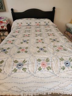 a bed with a white bedspread and flowers on it