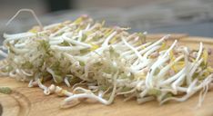 shredded sprouts sitting on top of a wooden cutting board