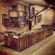 an empty room with some wooden boxes on the floor and brick wall behind it,