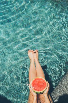 a woman's feet in the water holding a slice of watermelon with text overlay saying stay cool and healthy in this summer