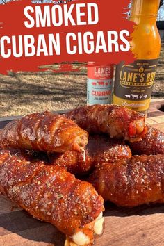 there are several pieces of meat on the table next to a bottle of smoked cuban cigars