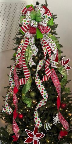 a christmas tree decorated with red, white and green ribbons