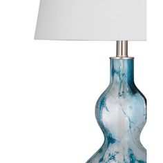 a blue glass lamp with a white shade