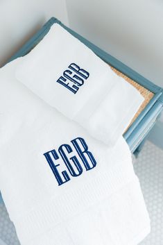 two folded towels sitting on top of a blue tray with the word eog printed on it