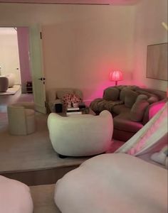 a living room filled with furniture and pink lighting