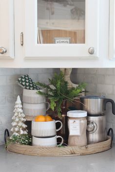 the kitchen counter is organized with coffee mugs and other holiday decorations, such as pine trees