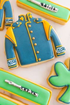 decorated cookies are arranged in the shape of jackets and shamrocks on a white surface