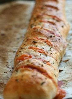 a piece of bread that is sitting on top of wax paper with herbs and seasoning