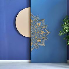 a blue and gold wall with a plant in the corner next to it on a table