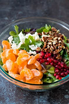 a glass bowl filled with salad and fruit