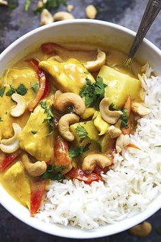 a white bowl filled with rice and vegetables next to cashews on the side