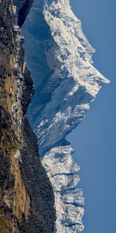 the mountain side is covered in snow and people are standing on it's sides