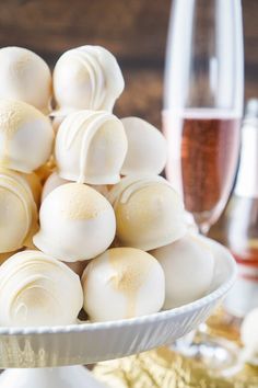 a white plate filled with marshmallows next to a glass of wine