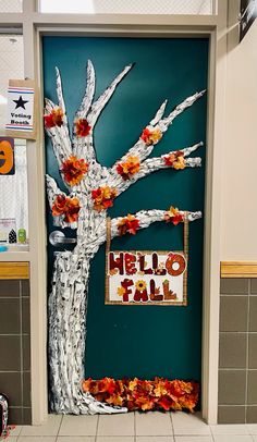 a door decorated with fall leaves and an autumn tree