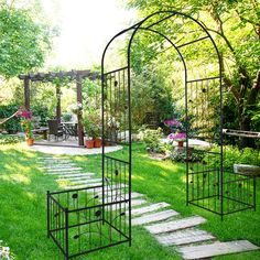 a garden with stone steps leading up to a pergolated gazebo and seating area