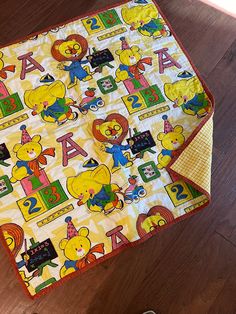 a yellow winnie the pooh blanket on top of a wooden floor