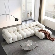 a white sectional sofa sitting on top of a rug