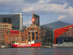 a large red boat in the water near some buildings