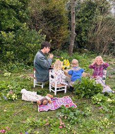 a group of people sitting in chairs on top of a lush green field