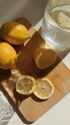 lemons and water sitting on a cutting board