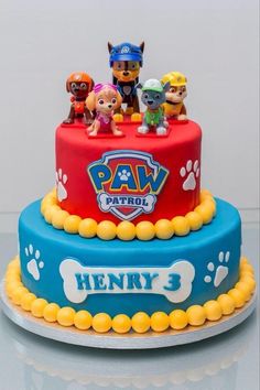 a birthday cake with paw patrol figures on top