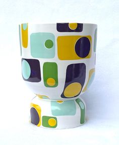 a colorful cup sitting on top of a white table