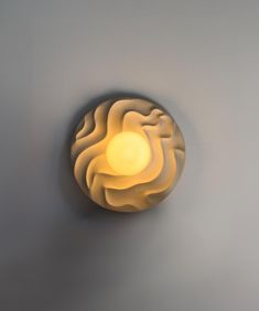 a light that is on the wall in front of a gray wall with white walls