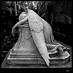 an angel statue laying on top of a grave