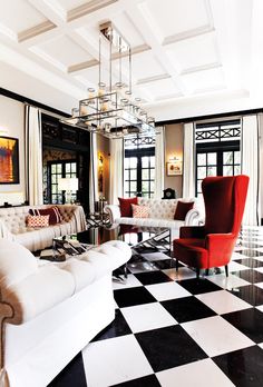 a living room filled with white furniture and black and white checkerboard flooring