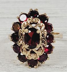 "L-2064  Vintage 1960's Garnet 14K Yellow Gold Ring 7.5 Cluster Retro Luxury Design  AMAZING VINTAGE 1960's NATURAL GARNET CLUSTER COCKTAIL SOLID 14K GOLD RING. WEAR ALONE ON WITH YOUR STACK. WONDERFUL COLOR & HIGHEST QUALITY. WONDERFUL HIGHEST QUALITY. JUST PART OF MY MOST RECENT ESTATE FINDS! FOLLOW ME TO SEE THEM ALL!    Brand: Unbranded Metal: 14K Yellow Gold Metal Purity: 14K Material:  Ring Size: 5.5 Other Dimensions: 3/4\" Form: Ring Luxury Age: Vintage Weight (Grams): 5.4 IT IS IN EXCELL Garnet Cluster Ring, Vintage Style Red Cluster Ring In 14k Gold, Vintage Gemstone Cluster Ring For Anniversary, Vintage 14k Gold Ruby Ring For Formal Occasions, Vintage Gold Cluster Ring With Gemstones, Vintage Yellow Gold Cluster Jewelry, Vintage Gemstone Cluster Ring, Vintage 14k Gold Cluster Ring For Formal Occasions, Vintage 14k Stamped Cluster Rings