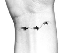 three birds flying in the air on a white wrist tattoo designs for women, small tattoos,