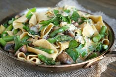 pasta with asparagus, mushrooms and parmesan cheese in a skillet