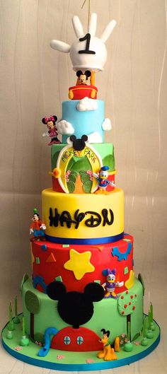 a multi - tiered cake with mickey mouse decorations