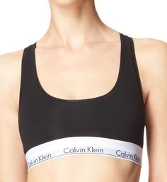 This soft bra offers light support and features the repeating Calvin Klein logo on the elastic underband. Wireless cups are lined with same fabric for gentle support. Elastic underband provides additional support and has the repeated Calvin Klein logo. Tall center front. Sewn-on elastic along top and bottom of sides for custom fit. Non-adjustable straps. Racerback for movement - great to wear under sleeveless tops. Pullover styling. Please Note: "Unlined" means that cups are unpadded. Calvin Kle 90s Workout Clothes, Calvin Klein Bras, Shape Magazine, Cotton Bralette, Cotton Bras, Racerback Bra, Calvin Klein Women, Black Bralette, Calvin Klein Woman